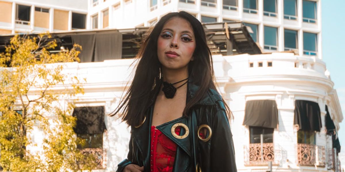 Stylish woman in vibrant attire against historic Puebla, Mexico cityscape.